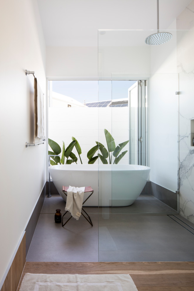 Design ideas for a modern bathroom in Sunshine Coast with white cabinets, a freestanding bath, white tiles, marble tiles, white walls, light hardwood flooring, a vessel sink, engineered stone worktops, an open shower, white worktops, a single sink, a floating vanity unit, a vaulted ceiling and panelled walls.