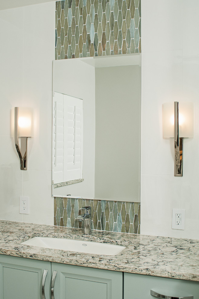 Ejemplo de cuarto de baño costero de tamaño medio con puertas de armario azules, bidé, baldosas y/o azulejos en mosaico, aseo y ducha, lavabo bajoencimera, encimera de granito y ducha con puerta con bisagras