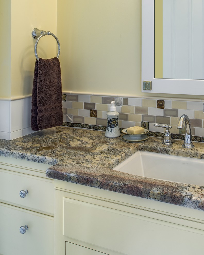 This is an example of a medium sized traditional ensuite bathroom in Portland Maine with white cabinets, a corner shower, ceramic tiles, a submerged sink and granite worktops.