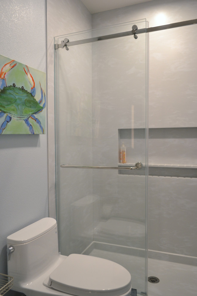 Inredning av ett klassiskt mellanstort grå grått badrum för barn, med skåp i shakerstil, vita skåp, en dusch i en alkov, grå kakel, klinkergolv i porslin, ett undermonterad handfat, bänkskiva i akrylsten, grått golv och dusch med gångjärnsdörr