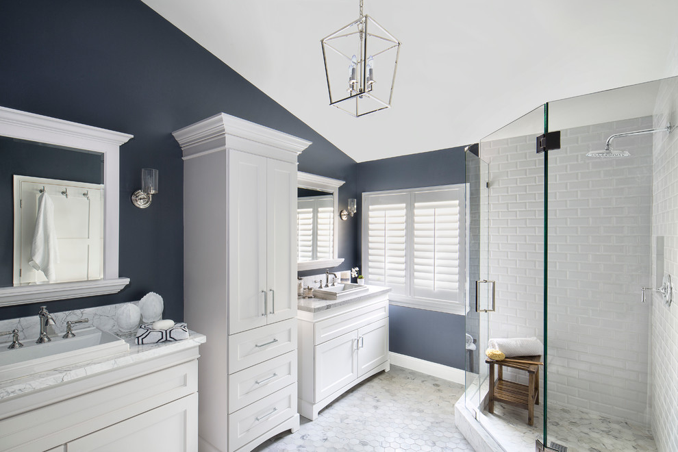 Идея дизайна: большая главная ванная комната в морском стиле с фасадами в стиле шейкер, белыми фасадами, угловым душем, белой плиткой, плиткой кабанчик, синими стенами, мраморным полом, настольной раковиной и мраморной столешницей