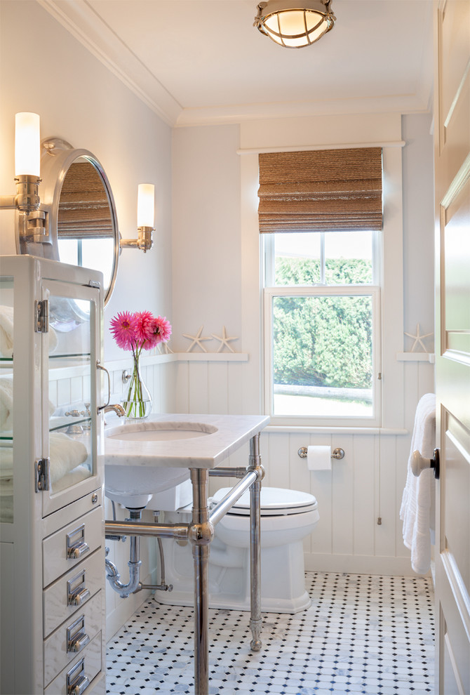 Example of a beach style bathroom design in Providence with a console sink, white cabinets and white walls