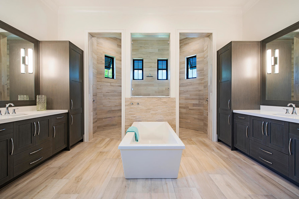 На фото: главная ванная комната в современном стиле с фасадами в стиле шейкер, темными деревянными фасадами, отдельно стоящей ванной, бежевой плиткой, врезной раковиной и открытым душем с