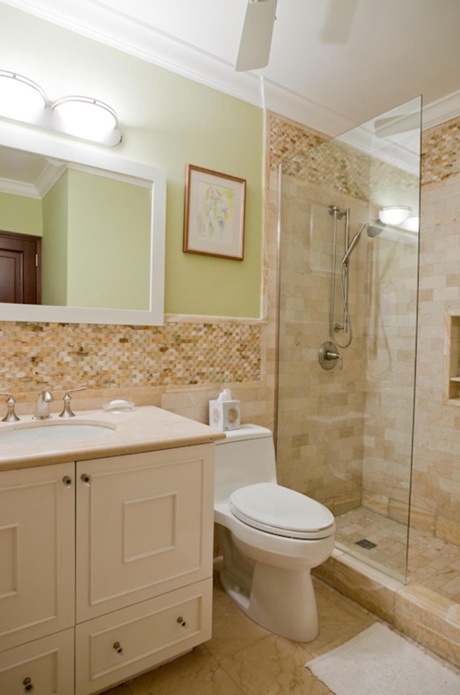 Immagine di una stanza da bagno tropicale di medie dimensioni con ante con bugna sagomata, ante bianche, doccia aperta, WC monopezzo, piastrelle beige, piastrelle a mosaico, pareti verdi, pavimento in marmo e lavabo sottopiano