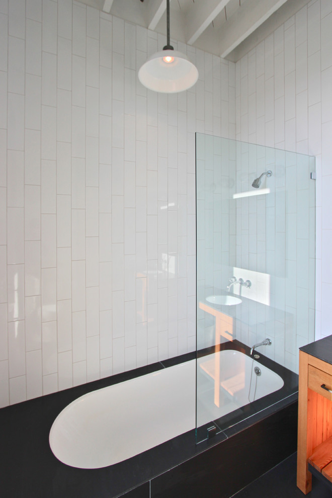 На фото: маленькая главная ванная комната в современном стиле с фасадами островного типа, фасадами цвета дерева среднего тона, полновстраиваемой ванной, душем над ванной, белой плиткой, керамической плиткой и полом из сланца для на участке и в саду