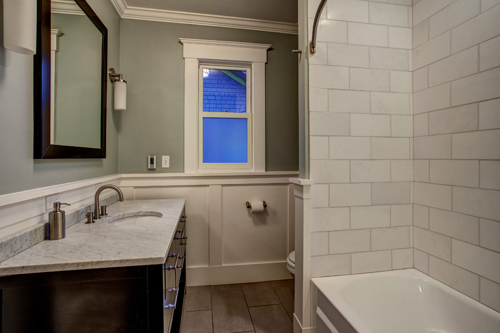 Inspiration for a medium sized classic bathroom in Seattle with flat-panel cabinets, dark wood cabinets, an alcove bath, a shower/bath combination, white tiles, stone tiles, grey walls, ceramic flooring, a submerged sink and marble worktops.