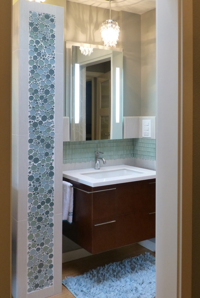На фото: маленькая главная ванная комната в стиле неоклассика (современная классика) с плоскими фасадами, темными деревянными фасадами, ванной в нише, душем в нише, унитазом-моноблоком, синей плиткой, стеклянной плиткой, серыми стенами, полом из бамбука, подвесной раковиной и столешницей из кварцита для на участке и в саду с