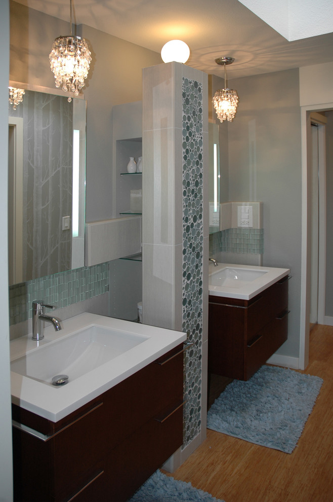 Photo of a small classic ensuite bathroom in Seattle with flat-panel cabinets, dark wood cabinets, an alcove bath, an alcove shower, a one-piece toilet, blue tiles, glass tiles, grey walls, bamboo flooring, a wall-mounted sink and quartz worktops.