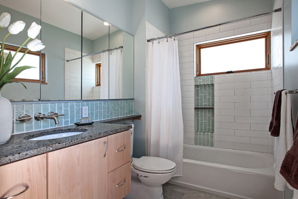 Пример оригинального дизайна: детская ванная комната среднего размера в современном стиле с врезной раковиной, плоскими фасадами, светлыми деревянными фасадами, столешницей из переработанного стекла, ванной в нише, душем над ванной, унитазом-моноблоком, синей плиткой, стеклянной плиткой, белыми стенами и полом из керамогранита