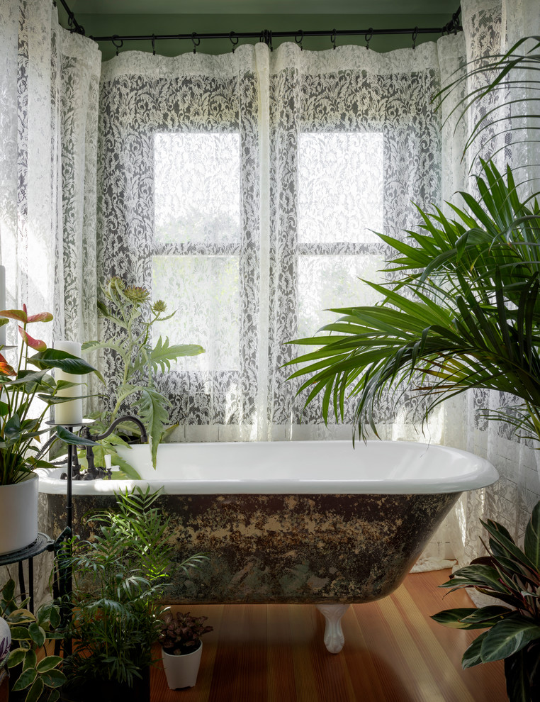 Inspiration för ett litet vintage en-suite badrum, med ett badkar med tassar, vit kakel, keramikplattor, gröna väggar, mellanmörkt trägolv och brunt golv