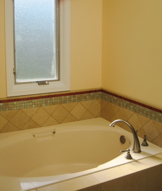Esempio di una stanza da bagno design con top in vetro