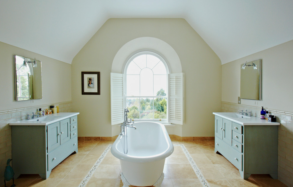 Ejemplo de cuarto de baño tradicional con bañera exenta, baldosas y/o azulejos de cemento y puertas de armario verdes