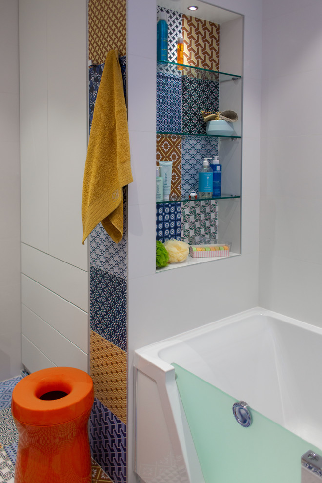 Idéer för mellanstora funkis vitt badrum för barn, med möbel-liknande, orange skåp, ett hörnbadkar, en dusch/badkar-kombination, en vägghängd toalettstol, flerfärgad kakel, keramikplattor, vita väggar, klinkergolv i keramik, ett integrerad handfat, bänkskiva i akrylsten, flerfärgat golv och dusch med skjutdörr
