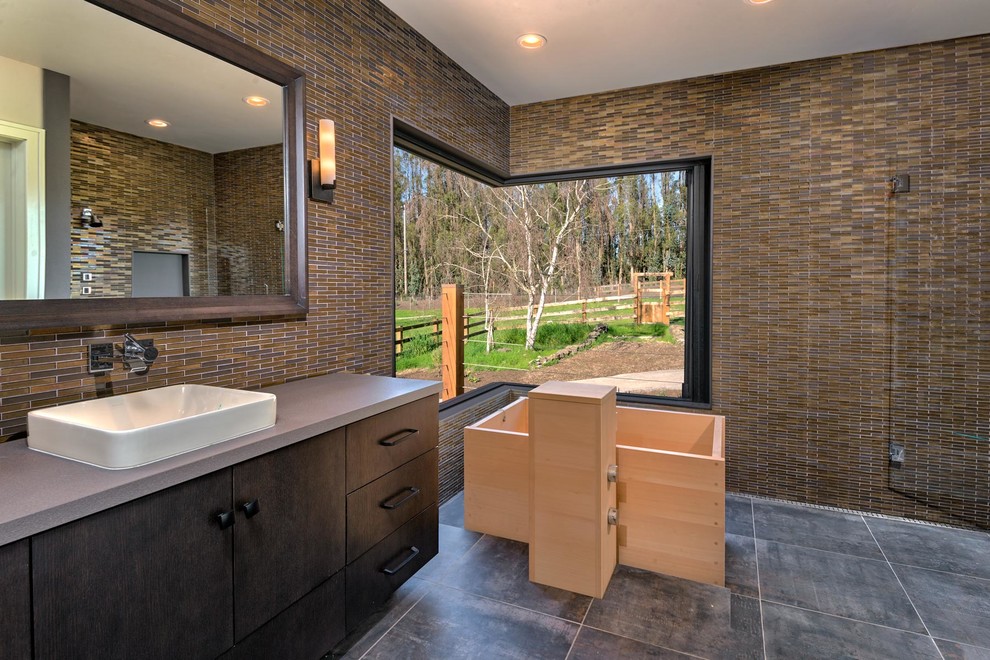 Идея дизайна: большая главная ванная комната в стиле кантри с плоскими фасадами, коричневыми фасадами, японской ванной, открытым душем, унитазом-моноблоком, разноцветной плиткой, стеклянной плиткой, коричневыми стенами, полом из керамической плитки, настольной раковиной, столешницей из бетона, серым полом и душем с распашными дверями