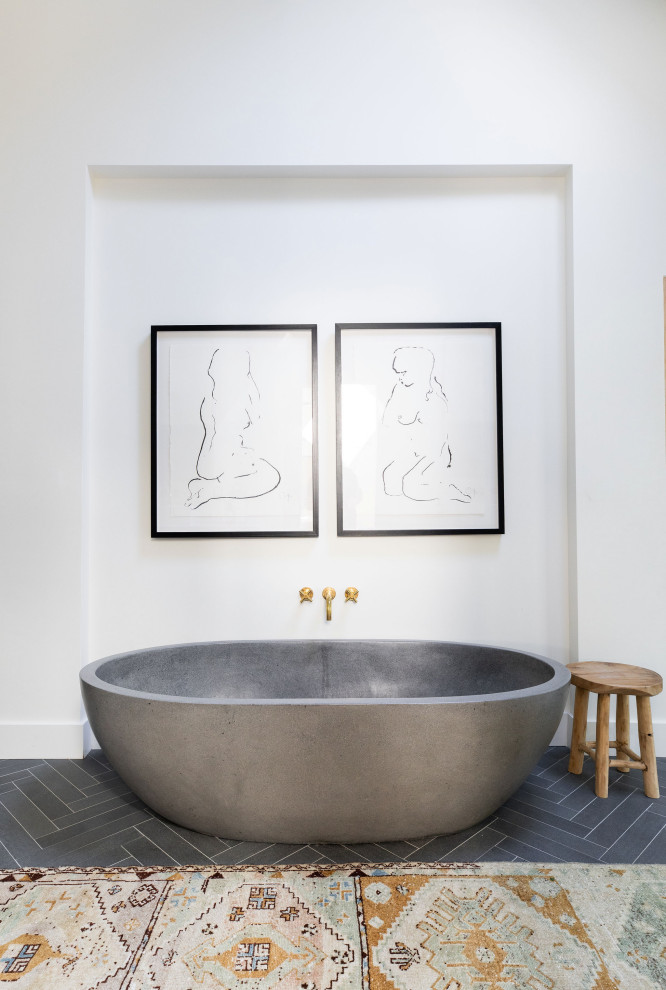 На фото: ванная комната в стиле кантри с отдельно стоящей ванной, белыми стенами и серым полом с