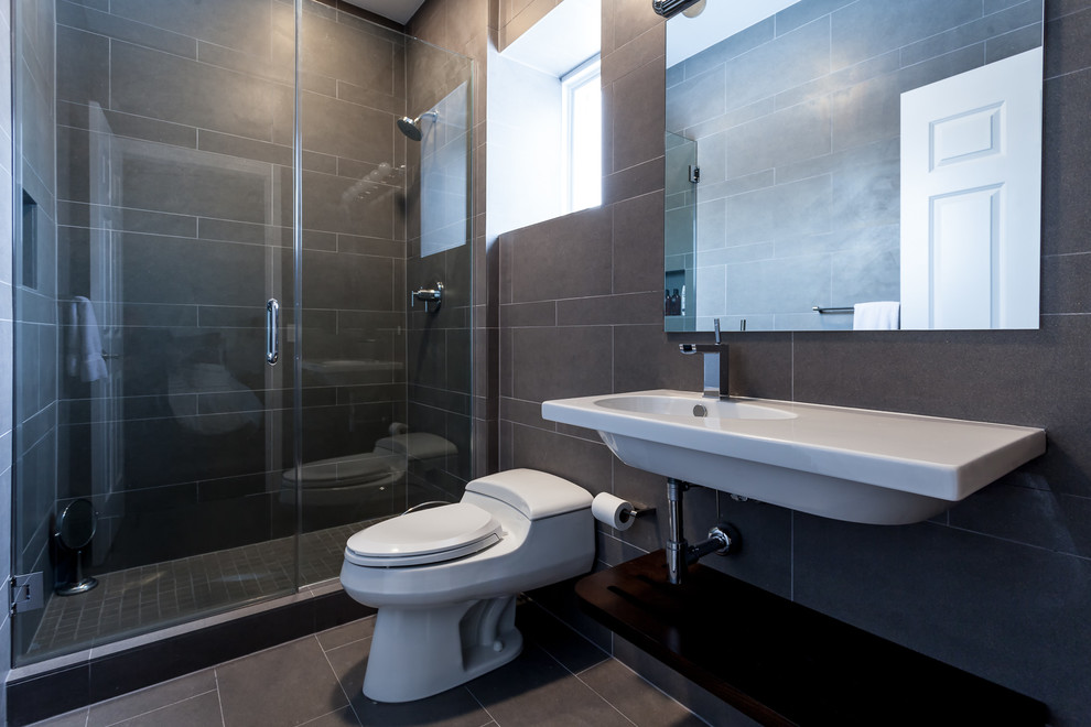Идея дизайна: ванная комната среднего размера в стиле модернизм с душем в нише, унитазом-моноблоком, черными стенами, полом из сланца, душевой кабиной, подвесной раковиной, столешницей из искусственного кварца, черным полом и душем с распашными дверями