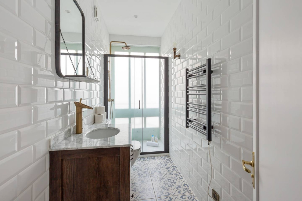 Exempel på ett mellanstort industriellt vit vitt badrum med dusch, med släta luckor, bruna skåp, en öppen dusch, en toalettstol med hel cisternkåpa, vit kakel, porslinskakel, vita väggar, klinkergolv i porslin, ett integrerad handfat, marmorbänkskiva, blått golv och dusch med skjutdörr