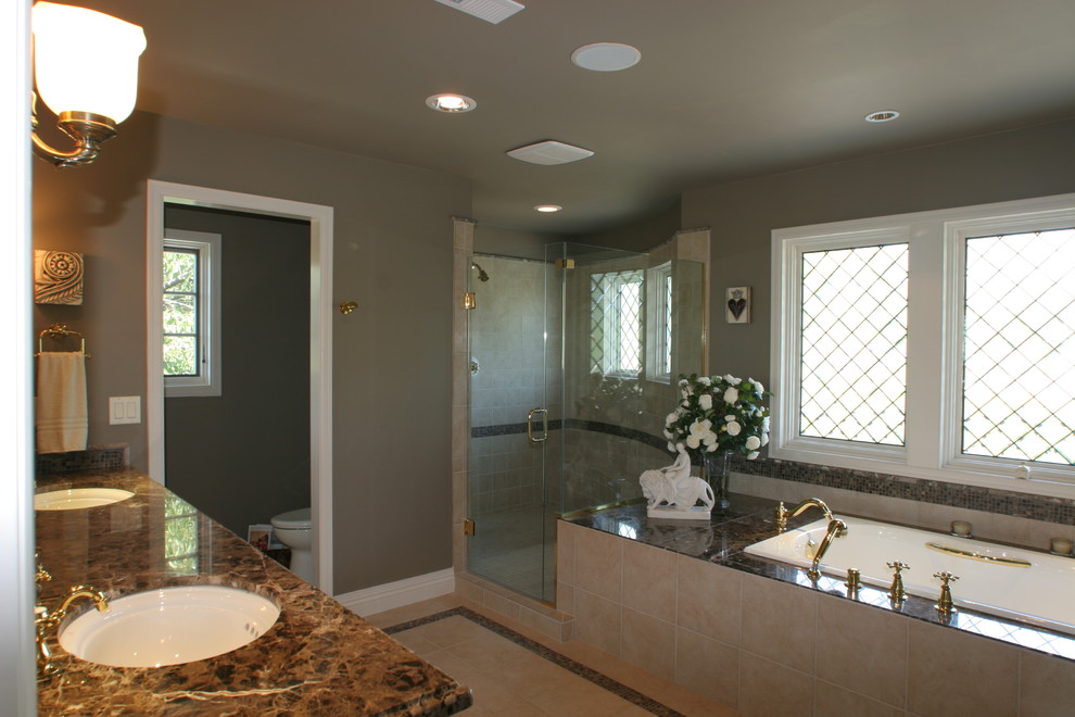 Idéer för stora medelhavsstil en-suite badrum, med ett undermonterad handfat, luckor med upphöjd panel, vita skåp, granitbänkskiva, ett platsbyggt badkar, en hörndusch, beige kakel, keramikplattor, grå väggar och kalkstensgolv