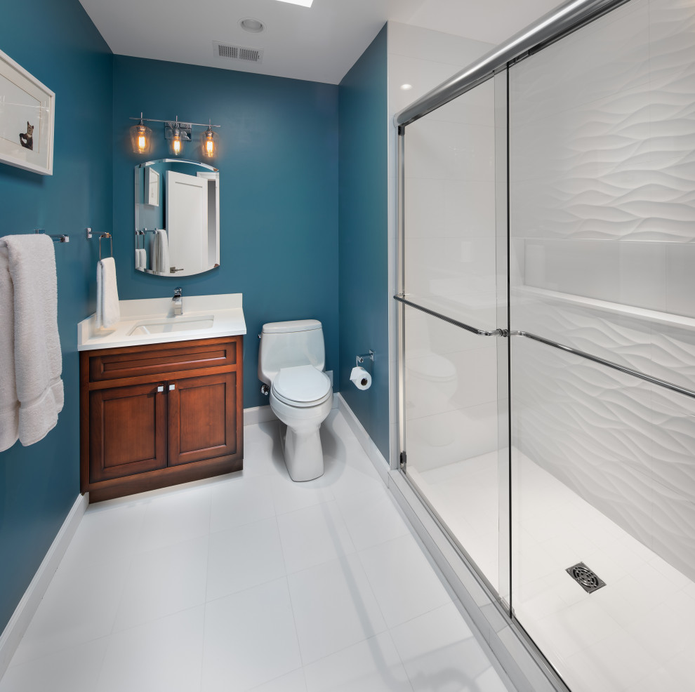 Пример оригинального дизайна: детская ванная комната среднего размера в стиле неоклассика (современная классика) с фасадами в стиле шейкер, темными деревянными фасадами, белой плиткой, керамогранитной плиткой, синими стенами, полом из керамогранита, врезной раковиной, столешницей из искусственного кварца, белым полом, душем с распашными дверями и белой столешницей