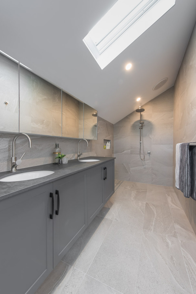 Modern inredning av ett stort grå grått badrum med dusch, med skåp i shakerstil, grå skåp, en öppen dusch, grå kakel, porslinskakel, klinkergolv i porslin, ett undermonterad handfat, grått golv och med dusch som är öppen