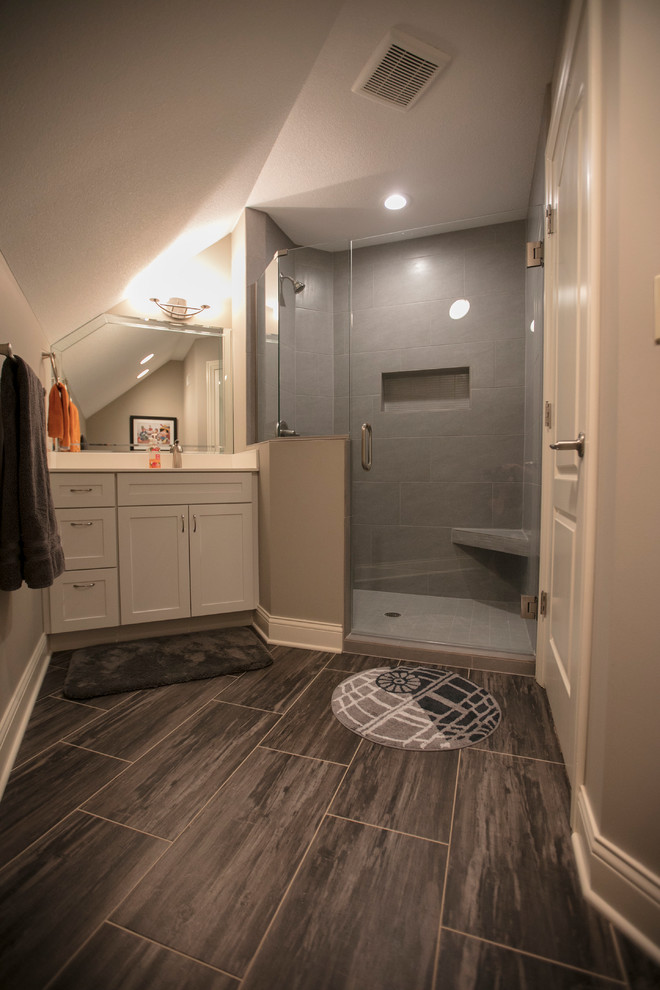 Photo of a small contemporary shower room bathroom in Kansas City with raised-panel cabinets, white cabinets, a corner shower, a two-piece toilet, grey tiles, porcelain tiles, grey walls, vinyl flooring, an integrated sink, onyx worktops, grey floors and a hinged door.