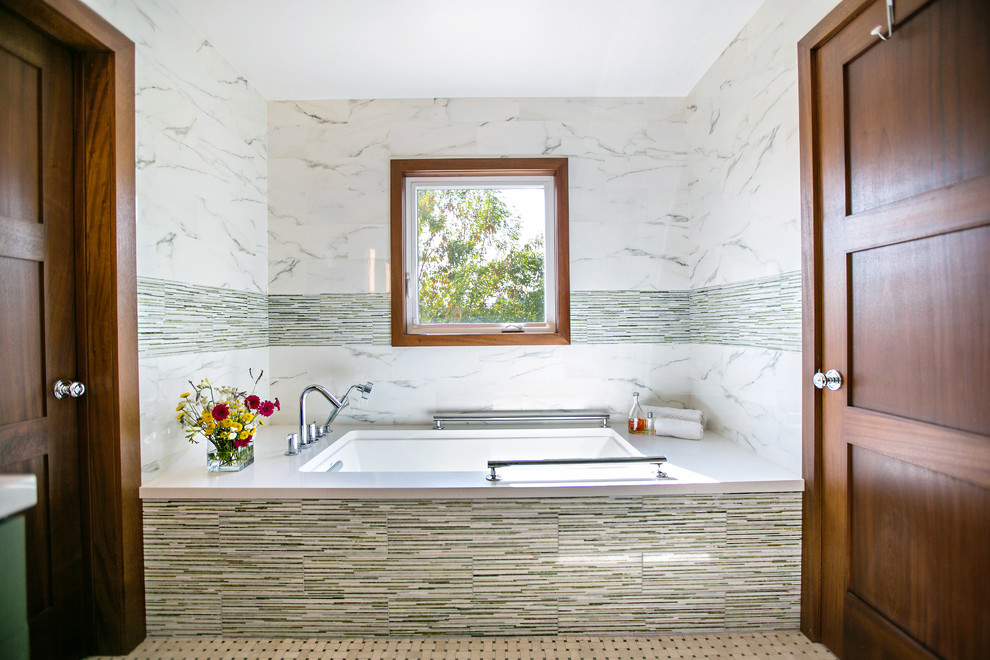 Example of a mid-sized transitional master green tile and porcelain tile mosaic tile floor corner shower design in Los Angeles with shaker cabinets, green cabinets, an undermount tub, a one-piece toilet, white walls, an undermount sink and quartz countertops