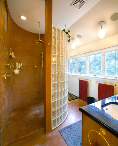 Cette image montre une salle de bain principale design en bois brun de taille moyenne avec un lavabo encastré, un plan de toilette en granite, une douche ouverte, un carrelage en pâte de verre, un mur blanc, sol en béton ciré et un placard avec porte à panneau surélevé.