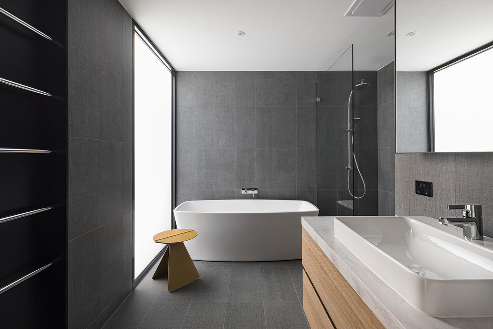 Свежая идея для дизайна: главная ванная комната в стиле модернизм с плоскими фасадами, бежевыми фасадами, отдельно стоящей ванной, угловым душем, серой плиткой, серыми стенами, настольной раковиной, серым полом, открытым душем и белой столешницей - отличное фото интерьера