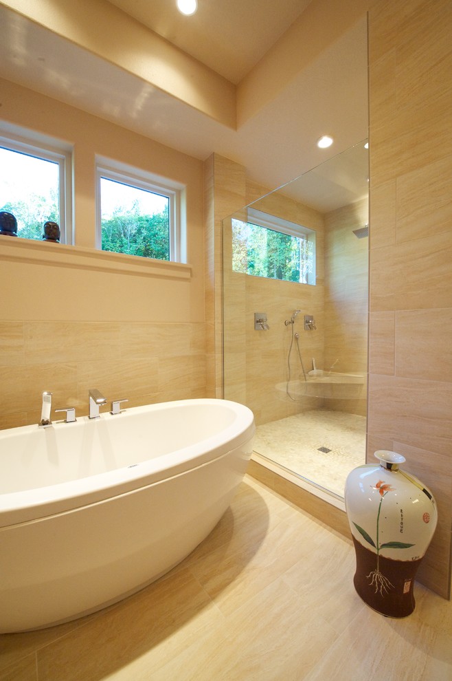 Modelo de cuarto de baño contemporáneo con bañera exenta y baldosas y/o azulejos de travertino