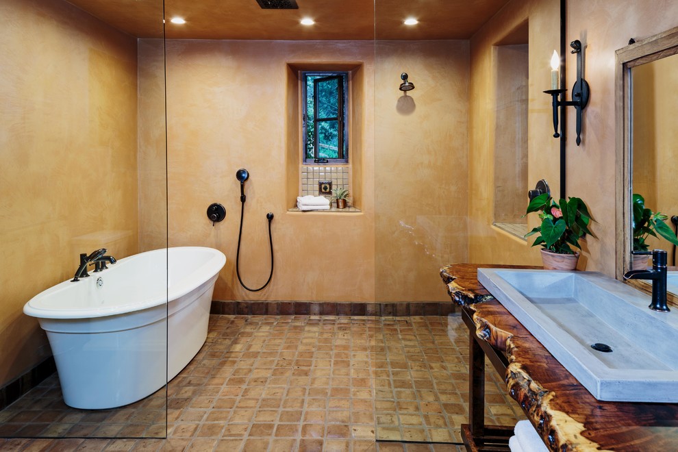 Large mediterranean ensuite bathroom in Miami with open cabinets, a freestanding bath, a walk-in shower, beige walls, terracotta flooring, a built-in sink, wooden worktops, brown floors and an open shower.