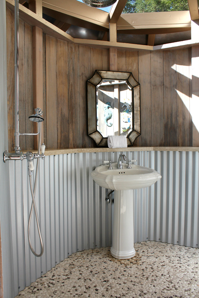 Imagen de cuarto de baño bohemio con lavabo con pedestal y suelo de baldosas tipo guijarro