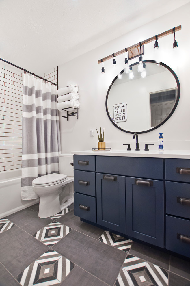 Свежая идея для дизайна: маленькая ванная комната в стиле модернизм с фасадами в стиле шейкер, синими фасадами, ванной в нише, душем над ванной, раздельным унитазом, белой плиткой, керамогранитной плиткой, белыми стенами, полом из керамогранита, врезной раковиной, столешницей из искусственного кварца, серым полом, шторкой для ванной, белой столешницей и душевой кабиной для на участке и в саду - отличное фото интерьера