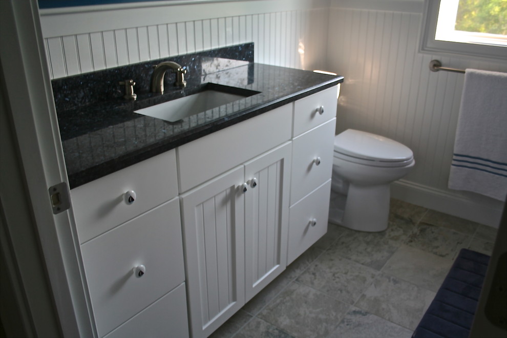 Diseño de cuarto de baño tradicional pequeño con armarios con rebordes decorativos, puertas de armario blancas, encimera de granito, sanitario de dos piezas, lavabo encastrado, paredes azules y suelo de baldosas de porcelana
