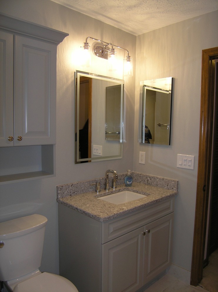 Photo of a classic family bathroom in Tampa with raised-panel cabinets, beige cabinets, an alcove shower, a two-piece toilet, porcelain tiles, grey walls, porcelain flooring, a submerged sink, granite worktops, grey floors and a hinged door.