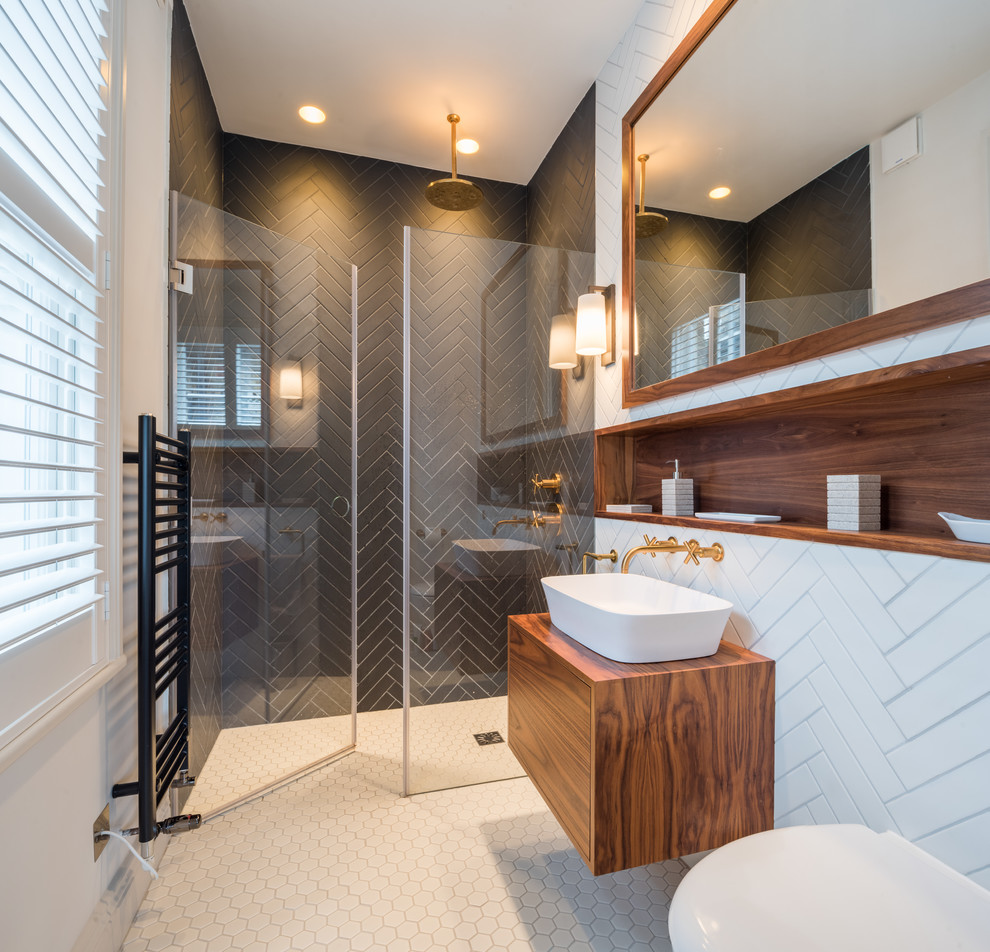 Inspiration för mellanstora moderna brunt badrum med dusch, med släta luckor, bruna skåp, våtrum, en toalettstol med hel cisternkåpa, vita väggar, ett väggmonterat handfat, träbänkskiva, vitt golv, dusch med gångjärnsdörr, svart kakel och mosaikgolv