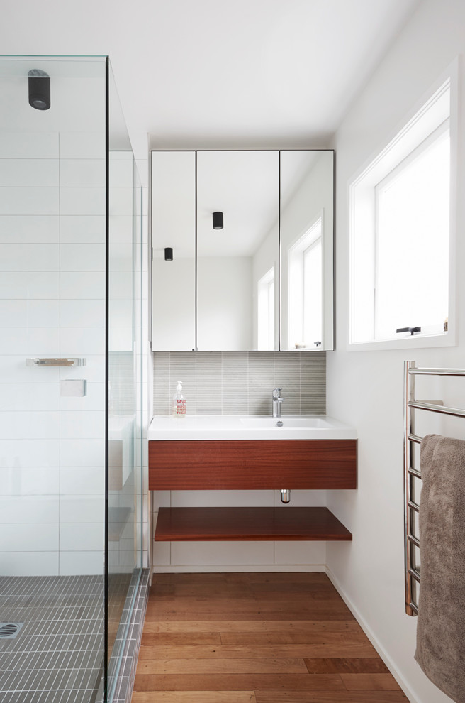 Esempio di una stanza da bagno contemporanea con lavabo integrato, doccia alcova e piastrelle grigie