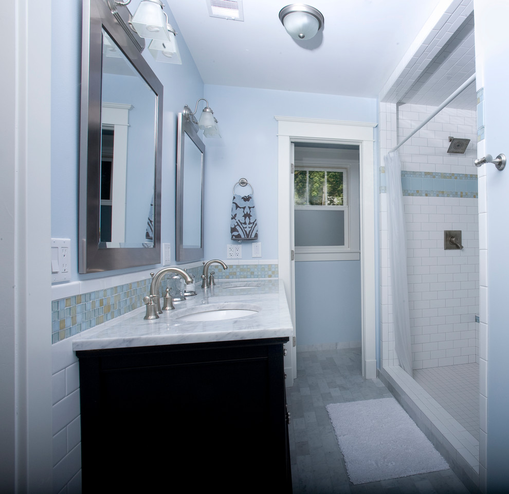 Idée de décoration pour une salle de bain principale craftsman de taille moyenne avec un placard avec porte à panneau encastré, des portes de placard noires, une douche double, un carrelage beige, un carrelage bleu, un carrelage en pâte de verre, un mur bleu, un lavabo encastré, un plan de toilette en marbre et une cabine de douche avec un rideau.