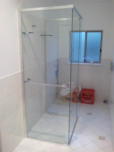 Immagine di una stanza da bagno moderna con doccia alcova e lastra di vetro