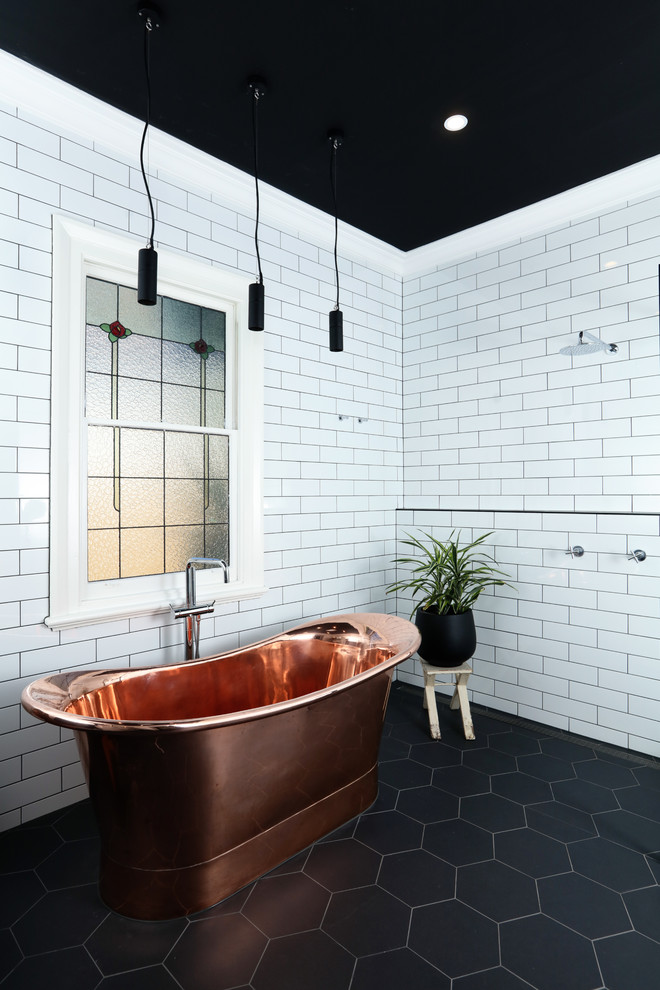 Свежая идея для дизайна: главная ванная комната в современном стиле с отдельно стоящей ванной, душевой комнатой, белой плиткой, плиткой кабанчик, полом из керамогранита, черным полом, открытым душем, белыми стенами и кирпичными стенами - отличное фото интерьера