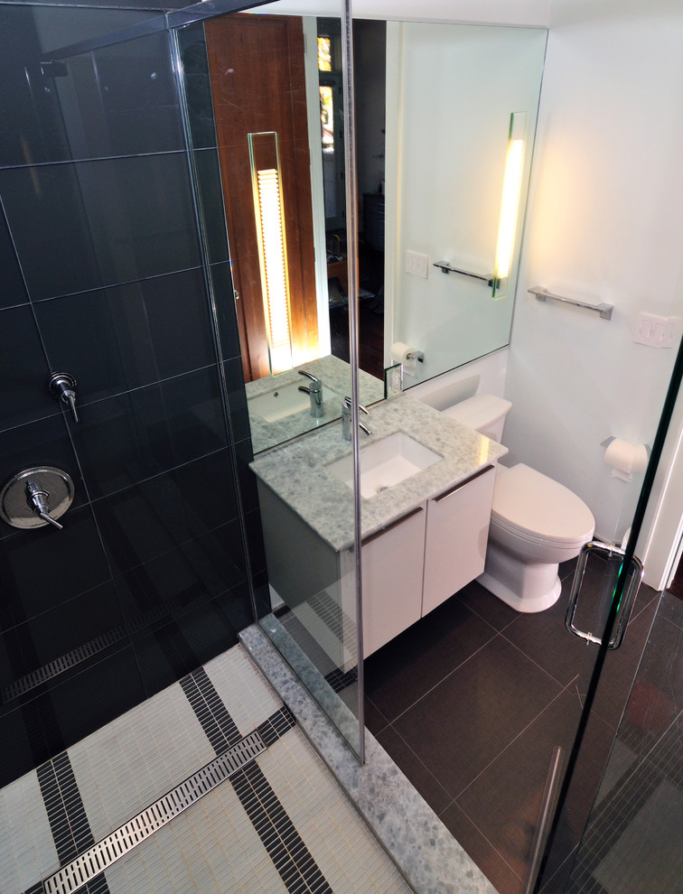 Idéer för mellanstora funkis en-suite badrum, med ett undermonterad handfat, släta luckor, vita skåp, marmorbänkskiva, en dubbeldusch, en toalettstol med hel cisternkåpa, blå kakel, glaskakel, vita väggar och klinkergolv i porslin