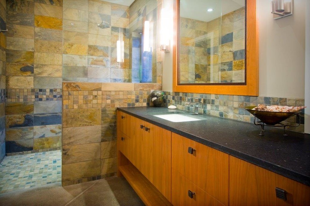 Großes Modernes Badezimmer En Suite mit flächenbündigen Schrankfronten, hellbraunen Holzschränken, bodengleicher Dusche, farbigen Fliesen, Steinfliesen, beiger Wandfarbe, Betonboden, Einbauwaschbecken und Mineralwerkstoff-Waschtisch in Vancouver