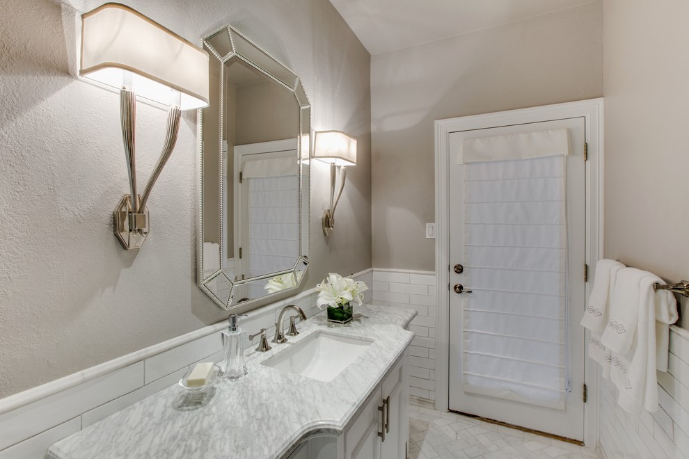 Inspiration for a medium sized classic bathroom in Austin with freestanding cabinets, white cabinets, an alcove bath, a shower/bath combination, a two-piece toilet, white tiles, metro tiles, grey walls, marble flooring, a submerged sink and marble worktops.