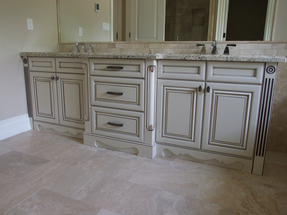 Mid-sized elegant master beige tile and stone tile limestone floor bathroom photo in Toronto with raised-panel cabinets, distressed cabinets, beige walls, an undermount sink and granite countertops