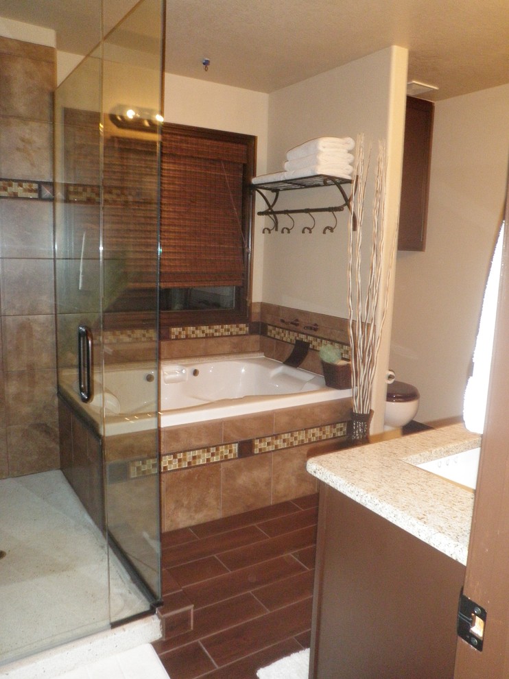 На фото: главная ванная комната в классическом стиле с врезной раковиной, столешницей из искусственного камня, накладной ванной, угловым душем, коричневой плиткой, керамической плиткой, бежевыми стенами и полом из керамической плитки с
