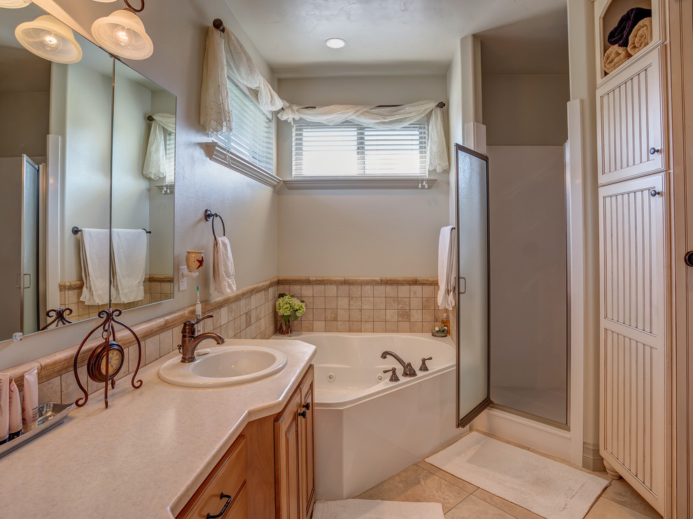 This is an example of a medium sized traditional ensuite bathroom in Salt Lake City with raised-panel cabinets, medium wood cabinets, quartz worktops, a corner bath, a corner shower, beige tiles, cement tiles and ceramic flooring.