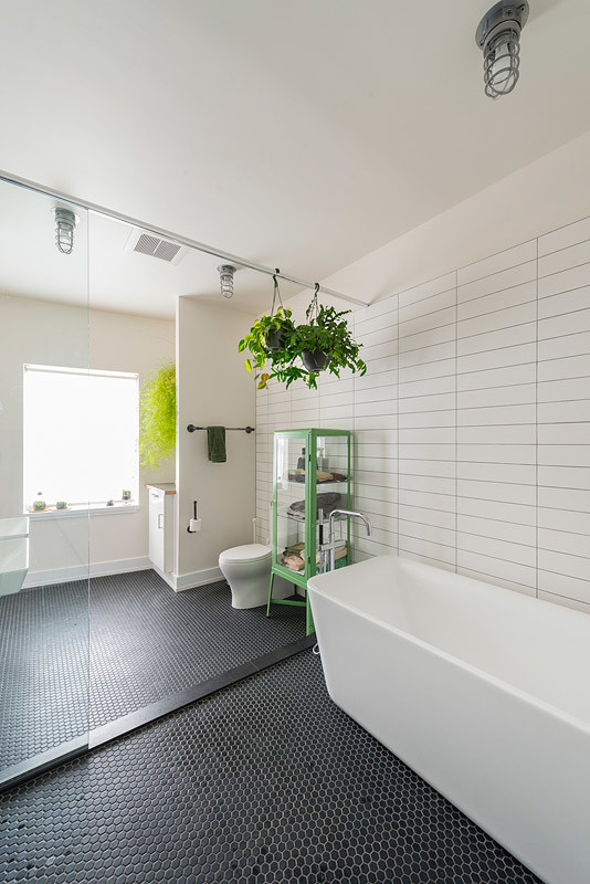 На фото: большая главная ванная комната в стиле лофт с отдельно стоящей ванной, душевой комнатой, унитазом-моноблоком, черной плиткой, белой плиткой, керамической плиткой, белыми стенами, полом из керамической плитки и подвесной раковиной с
