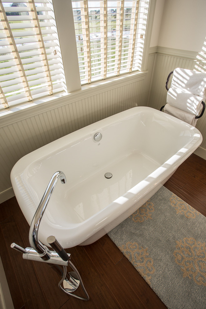 Foto de cuarto de baño principal campestre de tamaño medio con bañera exenta, suelo de madera en tonos medios y lavabo sobreencimera