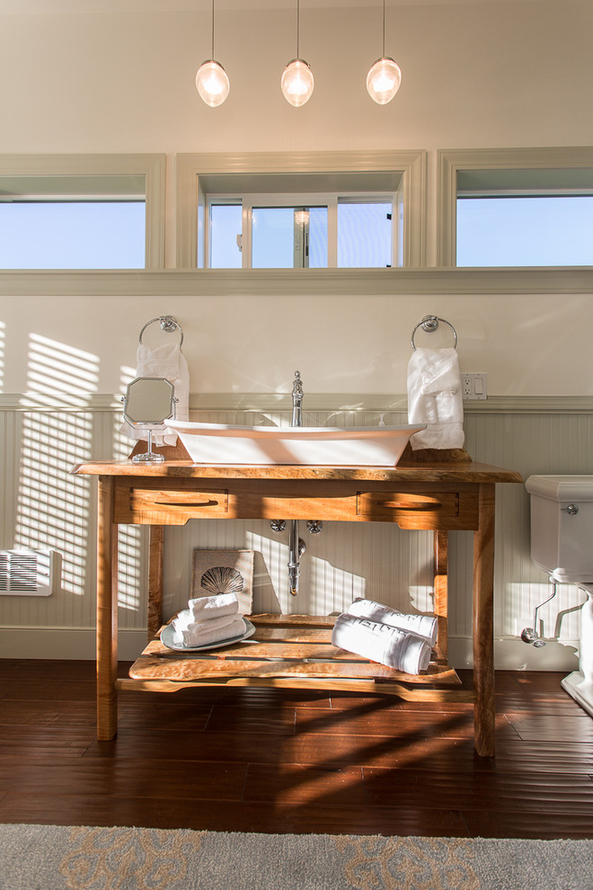 Modelo de cuarto de baño principal de estilo de casa de campo de tamaño medio con bañera exenta, suelo de madera en tonos medios y lavabo sobreencimera