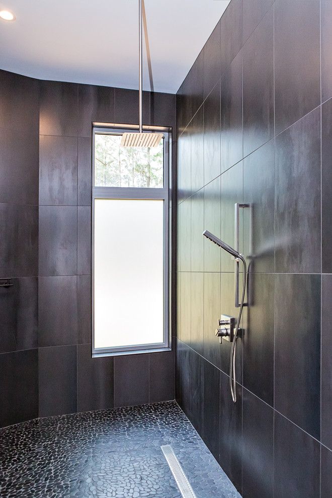 Idéer för att renovera ett stort funkis grå grått en-suite badrum, med släta luckor, skåp i ljust trä, en öppen dusch, en vägghängd toalettstol, svart kakel, porslinskakel, svarta väggar, klinkergolv i småsten, ett avlångt handfat, bänkskiva i betong, grått golv och med dusch som är öppen