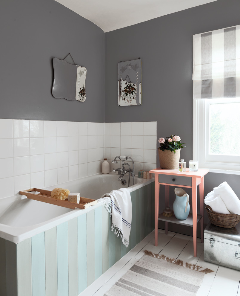 Foto di una stanza da bagno design con vasca ad angolo, pareti grigie, pavimento in legno verniciato e pavimento bianco